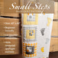 Front page of the Small Steps baby quilt PDF pattern, featuring a folded yellow and gray quilt with footprint appliqués on a wooden bed frame. Highlights include finished size 43" x 43", beginner-friendly design, and fat quarter compatibility.